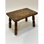 An Edwardian oak stool, the rectangular top with stylised floral relief carved centre panel