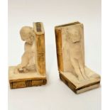 A pair of early 19thc plaster cast child figure book ends with decorated spines and leaves to books,