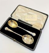 A pair of London silver gilt fruit spoons with panelled bowls complete with original presentation