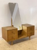 A mid century oak veneered dressing table, with swing mirror and four drawers on turned supports,