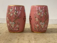 A pair of Chinese style pottery verandah stools of drum form, the pink ground having gilt bands