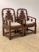 A large pair of Chinese style hardwood armchairs, upholstered seat, raised on square section