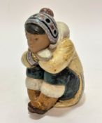 A Lladro Spanish pottery figure, Pensive Eskimo Boy, (18cm x 9cm x 13cm)