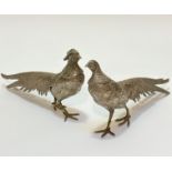 A pair of white metal cast table cock pheasant and hen pheasant ornaments, (14cm x 30cm x 5cm)