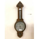 A late 19th/early 20th century oak aneroid barometer and thermomter with silvered registers H68cm