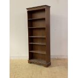 A mid 20th century mahogany floor standing open bookcase with dentil cornice, four adjustable and