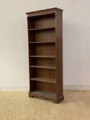 A mid 20th century mahogany floor standing open bookcase with dentil cornice, four adjustable and