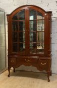An 18th century inspired hardwood display cabinet, the domed top over two doors with sectional