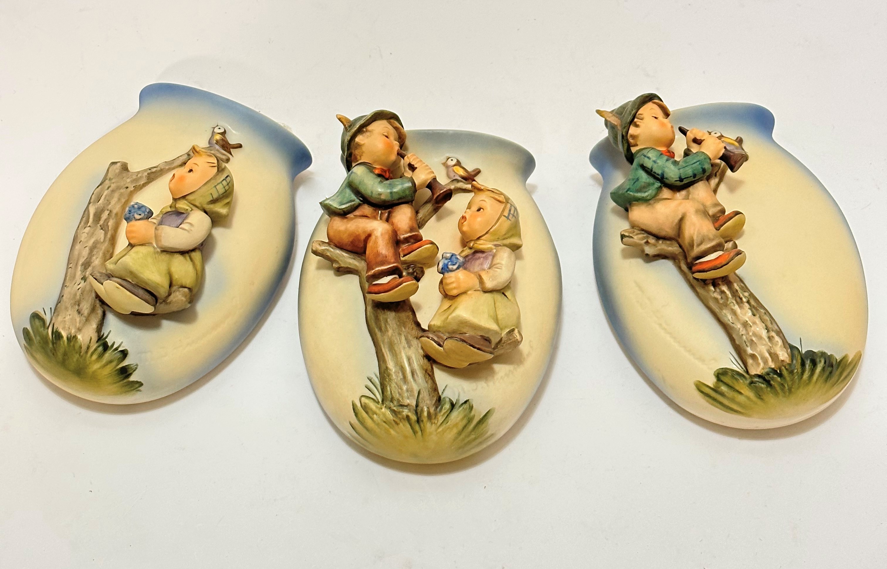 A group of three Hummel pottery figure oval wall pockets with Apple Tree boy and girl figures, (15.