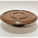 An Edwardian walnut table top circular Lazy Susan with moulded edge, raised on turned column and