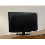 An LG 31" flat screen TV on stand, with power lead and remote
