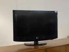 An LG 31" flat screen TV on stand, with power lead and remote