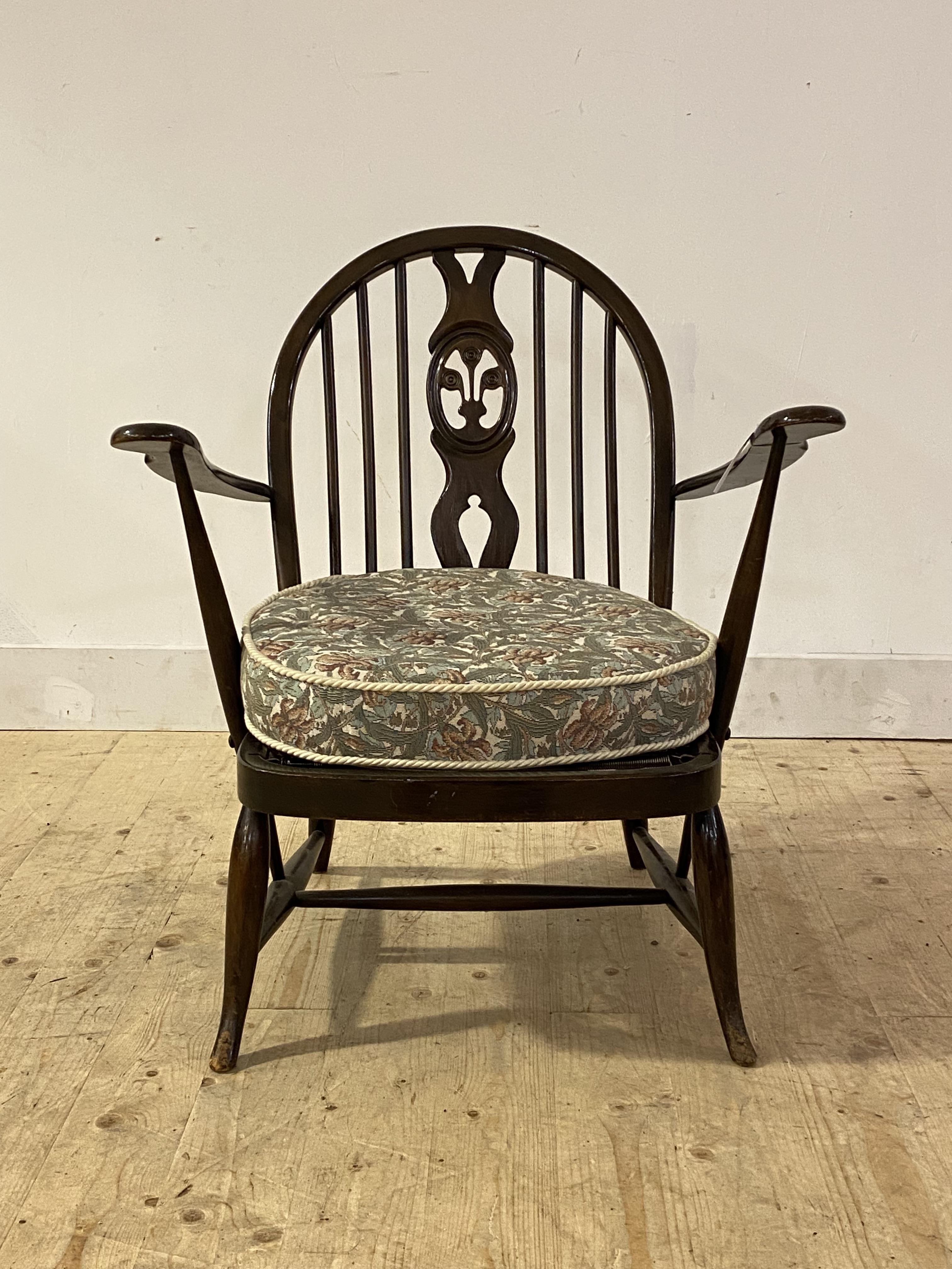 Ercol, a stained elm and beech lounge chair, with hoop, spindle and splat back over upholstered seat