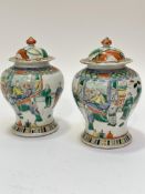 A pair of late 19thc Chinese Wacu palette baluster vases and covers decorated with courtly scenes