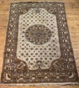 An Indian washed wool rug, the ivory field with floral medallion and spandrels, framed within a