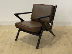 A mid century modern open arm lounge chair, ebonised frame with faux leather upholstered squab