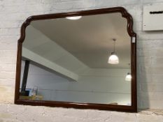 A large late 20th century mahogany framed wall mirror with undulating top, 133cm x 101cm