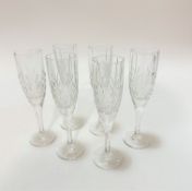 A set of six crystal moulded champagne flutes on faceted stems and circular moulded bases, (12cm x
