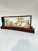 A Chinese lacquered glazed table showcase with balsa wood carved panel with trees, pagoda's, shell