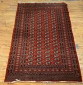 A hand knotted Afghan Bokhara rug, the red field with four rows of gulls within a multi line