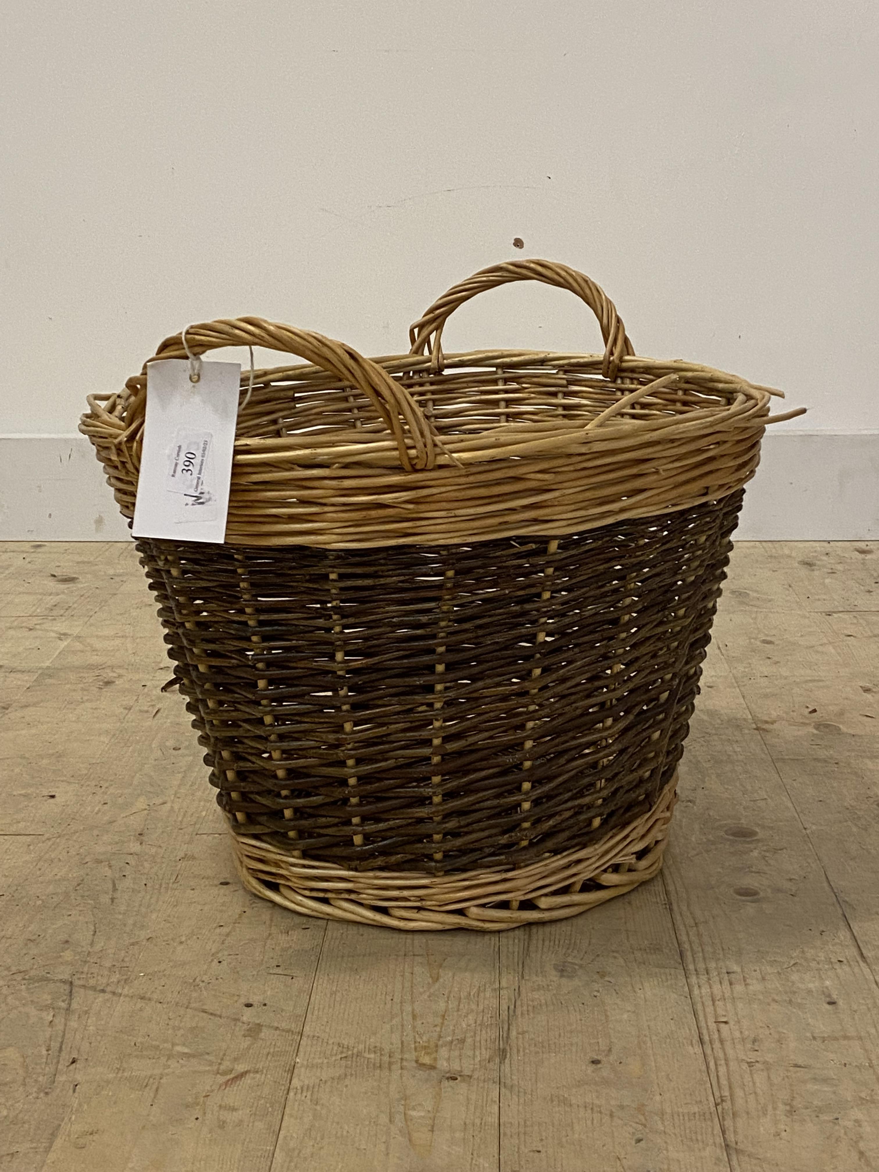 A twin handled wicker log basket, H40cm