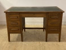 An oak desk, mid 20th century, the top inset with skiver writing surface over two slides, one long