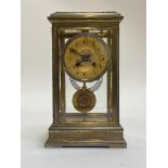 A French brass and four glass clock, circa 1890, the case with filigree frieze, pilasters and