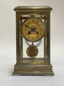 A French brass and four glass clock, circa 1890, the case with filigree frieze, pilasters and