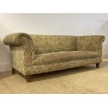 A Victorian style Chesterfield three seat sofa, upholstered in floral chenille fabric, raised on