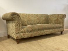 A Victorian style Chesterfield three seat sofa, upholstered in floral chenille fabric, raised on