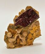 An Eastern carved tiger's eye panel with a pair of seated figures with raised arms and dove, with