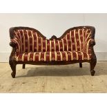A Victorian style upholstered childs sofa, wit floral carved undulating crest rail, serpentine
