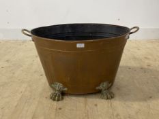 A 19th century brass and copper log bin of riveted construction, twin handled and standing on