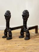 An imposing pair of cast iron fire dogs, formed with lion mask surmount and paw feet H52cm, L53cm
