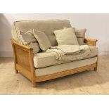 Ercol, a blonde elm and beech bergere two seat sofa, upholstered in oatmeal chenille fabric, with