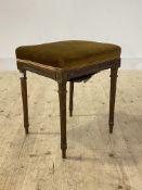 A Regency style walnut stool, circa 1930s, the upholstered top over leaf carved frieze raised on