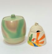 A Past Times beehive shaped honey pot with bee mounted top and a stylised Deco style building with