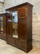 A late 19th / early 20th century mahogany triple wardrobe, three doors enclosing slides, drawers and