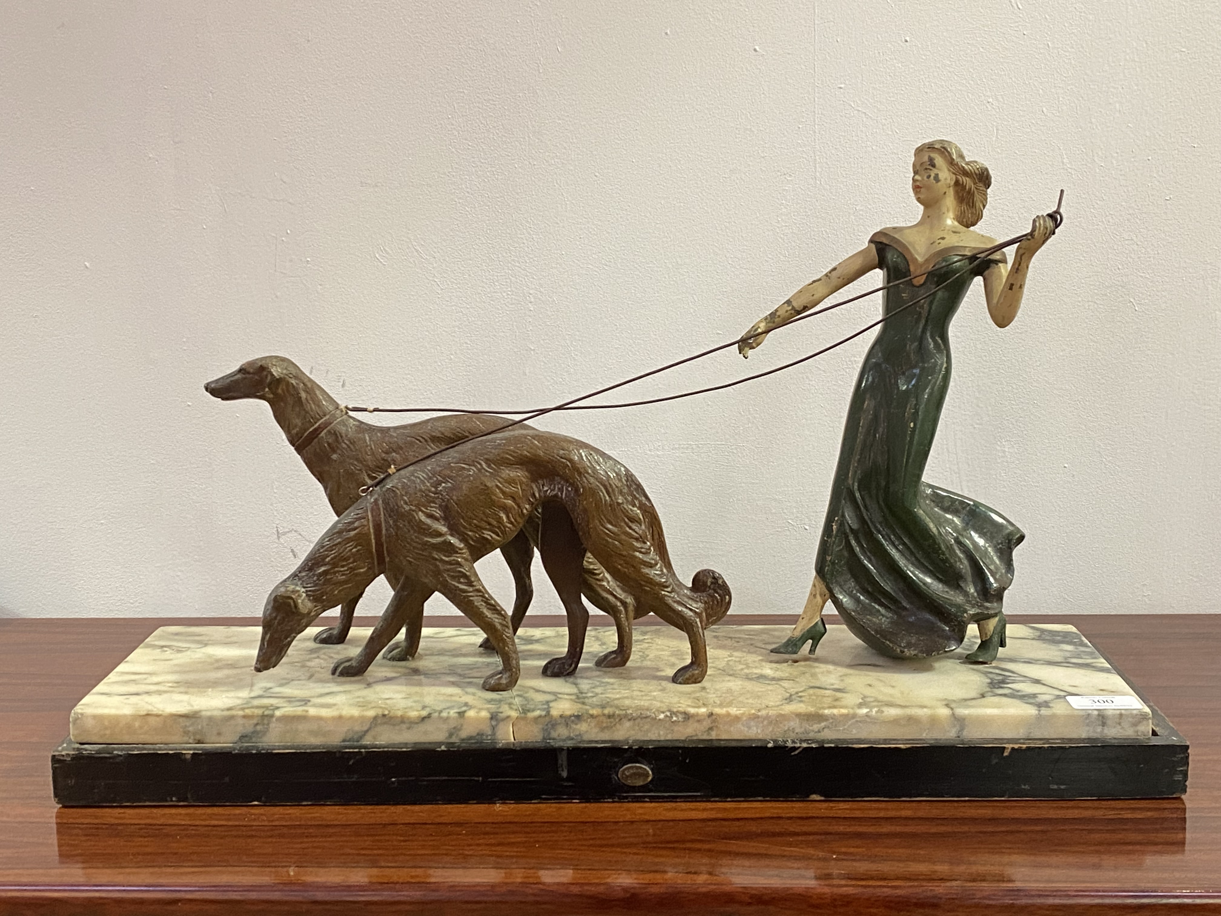 A French Art Deco period painted bronze sculpture of a lady walking two borzoi dogs, circa 1930's,