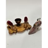 A Continental olive wood shaped pin cushion and bobbin stand with centre egg cup shaped holder,