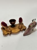 A Continental olive wood shaped pin cushion and bobbin stand with centre egg cup shaped holder,