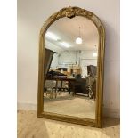 A Large Victorian wall mirror, the arched over painted gilt frame with shell and scrolling