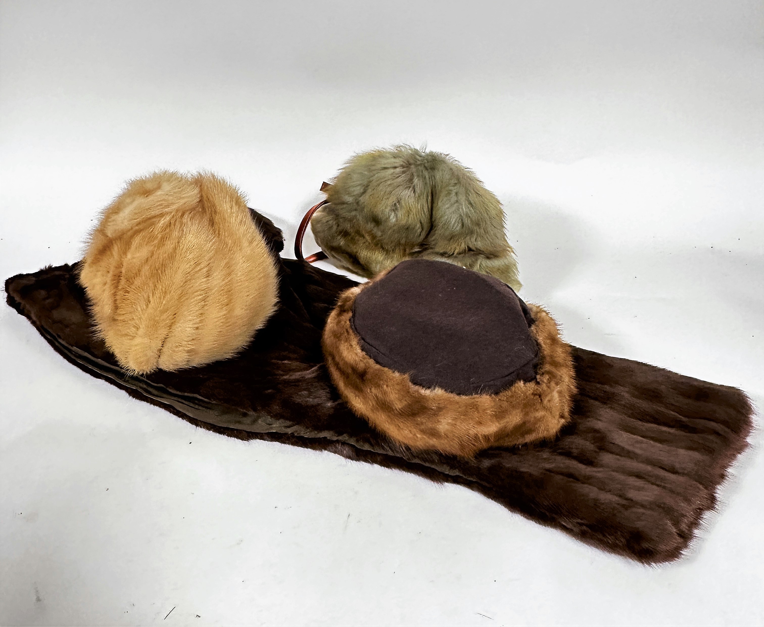 A black dyed beaver skin muff with satin lining, (24cm x 23cm), a musquash muff and hat, (muff