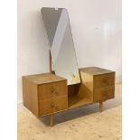 A mid century oak veneered dressing table, with swing mirror and four drawers on turned supports