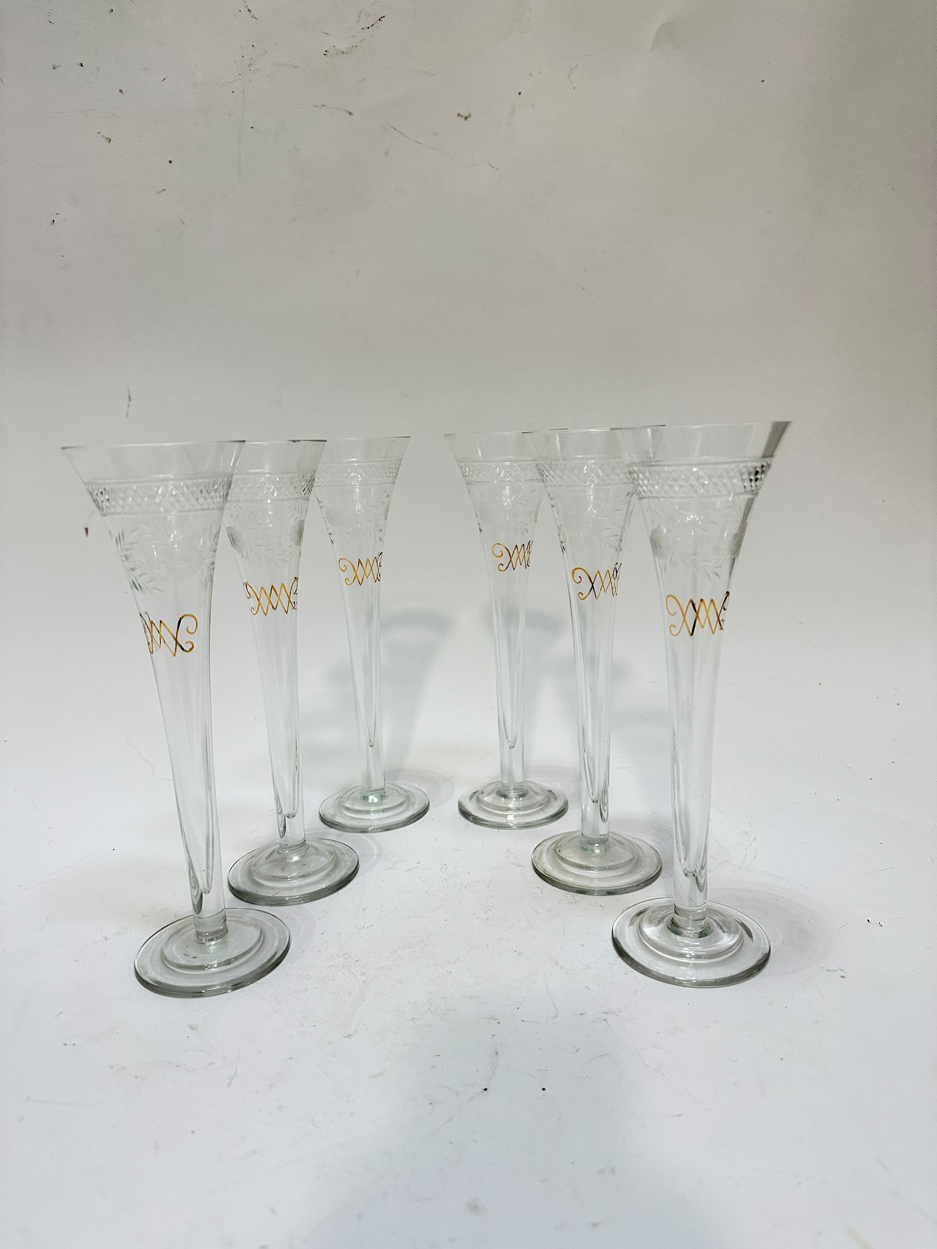 A set of six Edwardian style engraved champagne flutes with gilded decoration, (23cm x 7cm) show
