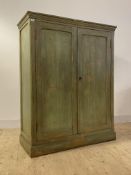 A 19th century continental rustic green painted pine cupboard, the moulded top over twin panelled