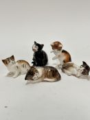 A group of five Royal Doulton china miniature cat figures, including two sleeping tabby cats, two