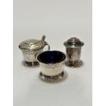 An Edwardian Birmingham silver three piece condiment set comprising salt with blue glass liner (h