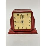 An American Gilbert Art Deco tin plate red enamelled alarm clock with enamelled dial and stylised