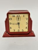 An American Gilbert Art Deco tin plate red enamelled alarm clock with enamelled dial and stylised